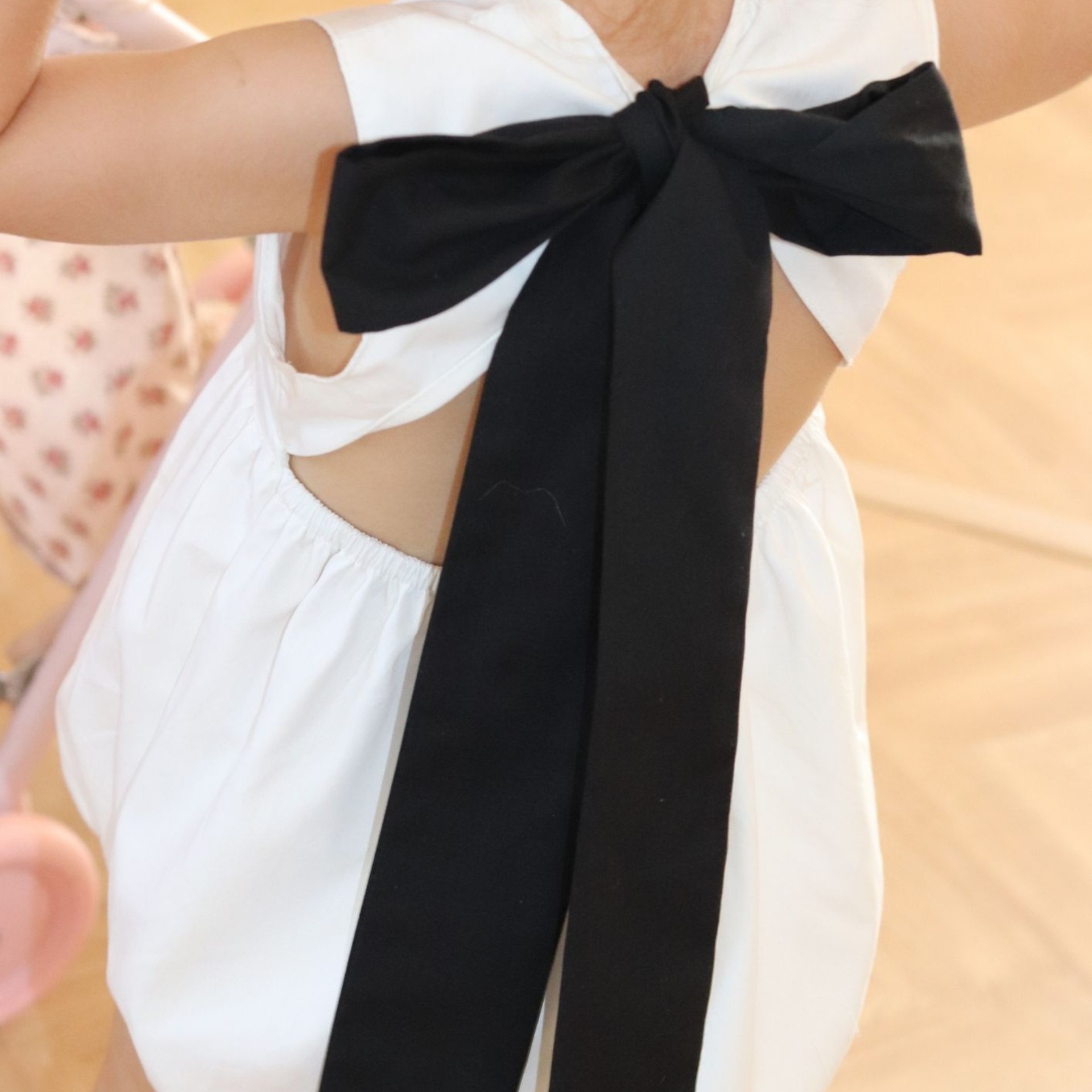 Barboteuse blanche avec un noeud noir