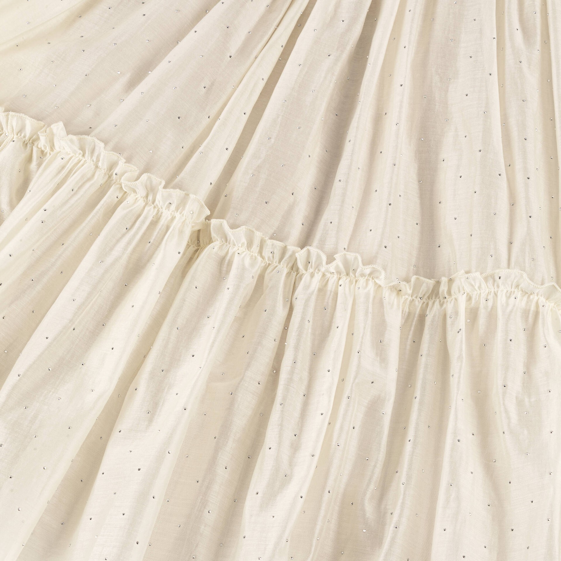 Robe en voile blanc cassé ornée de clous argentés