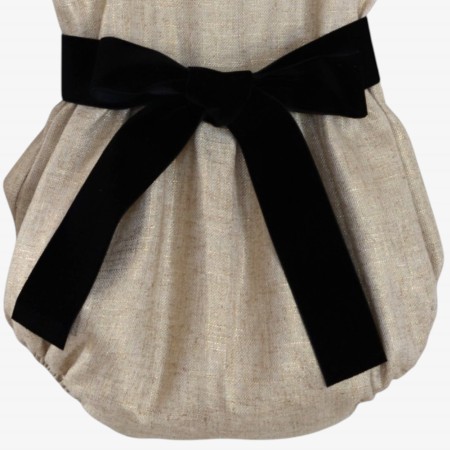Golden linen romper with a black velvet bow.
